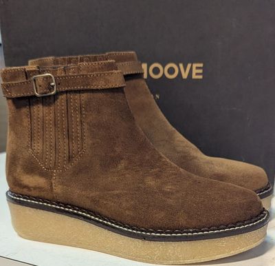 un gros plan sur une paire de bottes marron posées sur une table