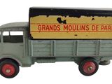 un camion miniature sur lequel est accrochée une pancarte à l'arrière