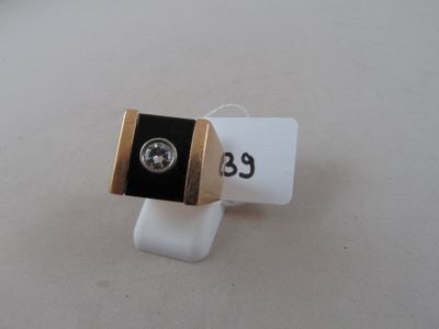 a black and gold ring with a diamond on it