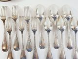 a lot of forks and spoons that are on the table