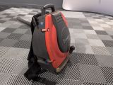 a red and black backpack sitting on a black and white checkered floor