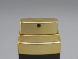 a black and gold perfume bottle next to a black box