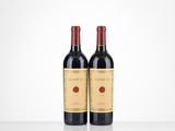 two bottles of red wine sitting on top of a table
