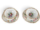 pair of antique porcelain tea cups and saucers with floral designs