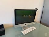 a glass desk with a computer monitor and keyboard on it
