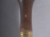 a small wooden object with a metal handle on a table
