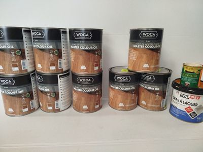several cans of wood are lined up on a shelf
