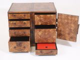 an image of a wooden chest of drawers with a red drawer underneath it