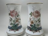 deux vases avec des fleurs peintes dessus, posés sur une table