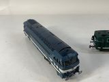 two toy trains sitting next to each other on a white surface