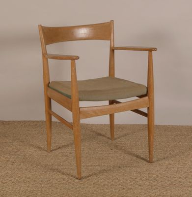 une chaise en bois avec une assise verte posée sur le tapis
