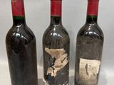 trois bouteilles de vin posées l'une à côté de l'autre sur une table