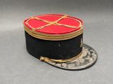 un chapeau rouge et noir orné d'un ruban doré