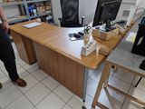 un homme debout devant un bureau sur lequel se trouve un ordinateur