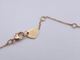 a close up of a gold chain with a heart on it