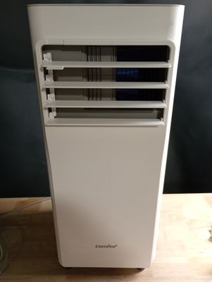 un climatiseur blanc posé sur une table en bois