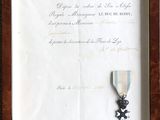 photo encadrée représentant une médaille ornée d'un ruban et d'une lettre