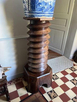 une grande table en bois sur laquelle est posé un vase bleu et blanc