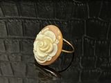 une bague ornée d'une fleur posée sur une surface noire