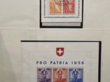 two framed stamps of different colors on a wall in a room