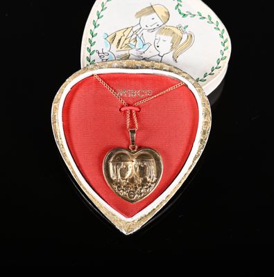 une boîte en forme de cœur contenant un pendentif en forme de cœur doré