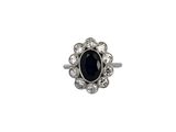 gros plan d'une bague avec une pierre noire entourée de diamants blancs