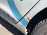 a close up of a white car with a blue stripe on it