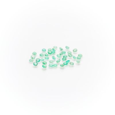 a pile of green glass beads on a white surface