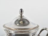 a silver tea pot with a lid on a table