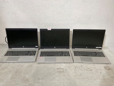 quatre ordinateurs portables sont alignés sur une table
