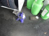 une pince à pneus qui se trouve à côté de quelques bouteilles vertes
