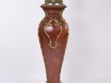 a tall vase with a clock on top of it