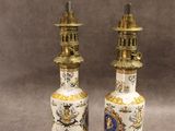 une paire de vases chinois anciens posés sur des socles, sur fond gris