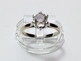 une bague ornée d'un diamant posé sur une monture transparente