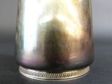 a silver vase that is sitting on a table