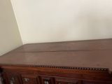 a wooden dresser with drawers and a clock on top of it