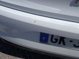 a close up of a white car with a license plate on it