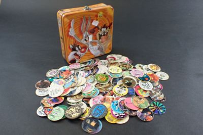 a suitcase full of buttons on a table next to a pile of them