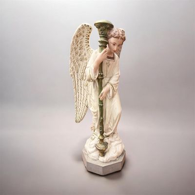une statue représentant un ange tenant un vase, posée sur un socle