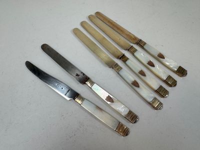 several different types of knives are lined up on a table