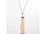 a white pearl and silver necklace with a tassel on a chain