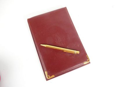 a red notebook with a gold pen on top of it