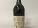 une vieille bouteille de vin posée sur une table blanche
