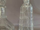 two clear glass bottles sitting next to each other on a table