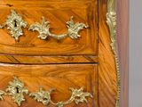 a small wooden chest of drawers with a marble top