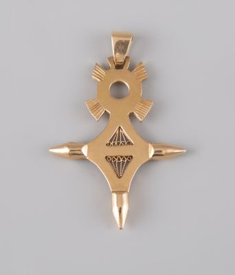 an image of a gold pendant with a cross on it