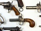 many different types of guns displayed on the wall