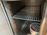 an open refrigerator with a bucket of ice cream inside of it