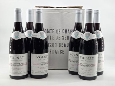 three bottles of wine are sitting in front of a white bag