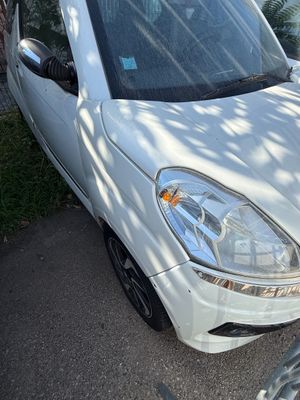 une petite voiture blanche garée sur le bord de la route